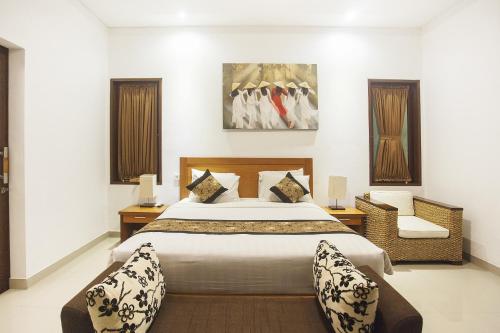 1 dormitorio con 1 cama grande y 1 silla en Kubu Manggala Villas Seminyak, en Seminyak