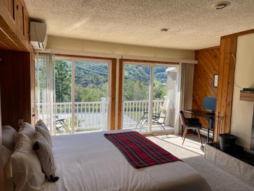 1 dormitorio con 1 cama grande y balcón en SPECTACULAR CATSKILLS 4 BEDROOM VACATION OASIS- Gorgeous Hunter Mountain Views!, en Hunter