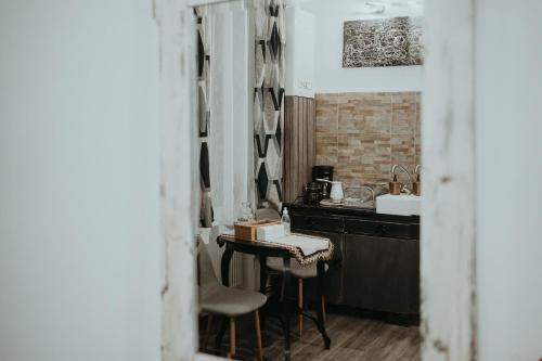 a kitchen with a sink and a table with chairs at Urbino Casa in Cluj-Napoca