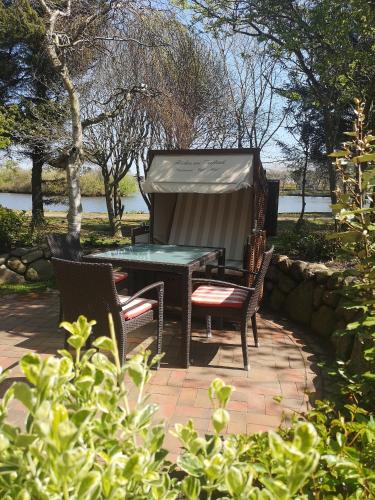a patio with a table and chairs on a brick patio at Fitschen am Dorfteich in Wenningstedt