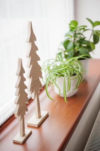 two wooden christmas trees on a table next to a plant at Žltý Dom in Terchová