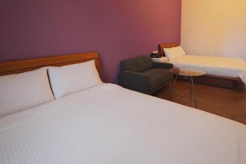 a bedroom with a bed and a chair and a bed and a chair at Taitung city-cottage B&B in Taitung City