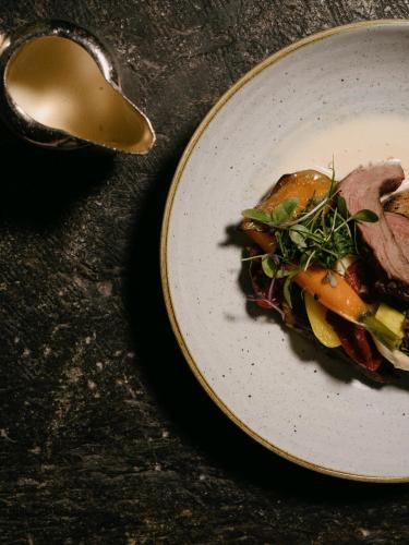 a plate of food on a table with a spoon at BEAUSiTE Zermatt in Zermatt