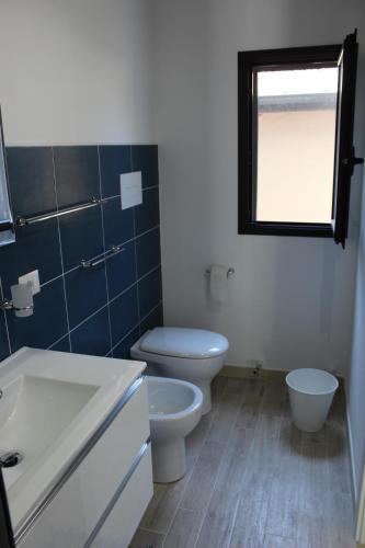 a bathroom with a toilet and a sink and a window at Anthiros Siracusa in Siracusa