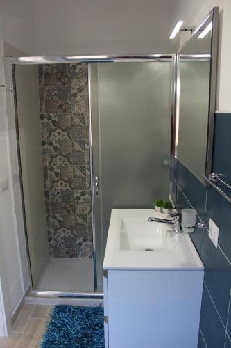 a bathroom with a shower and a white sink at Anthiros Siracusa in Siracusa