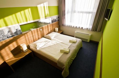 ein Schlafzimmer mit einem Bett in einem grünen Zimmer in der Unterkunft Hotelík Košice in Košice