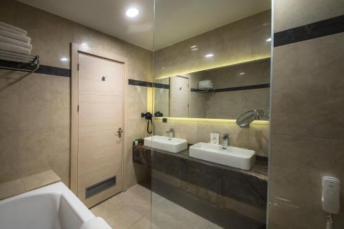 a bathroom with two sinks and a mirror at Hilly Hotel in Edirne