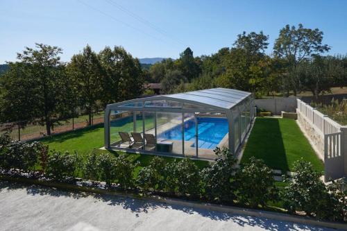 uma casa com piscina numa casa de vidro em Apartamentos Río Sil em Sober