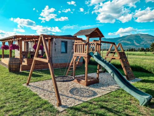 un parque infantil con tobogán y una casa en Liptovalley- mobilné domy s wellnessom en Liptovská Kokava