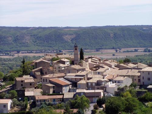 a village with a clock tower on top of it at Agréable appartement au calme in Villeneuve