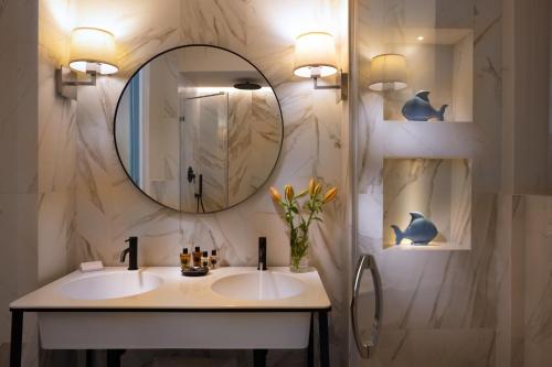 a bathroom with two sinks and a mirror at La Malandrina - Apartments & Suites in Taormina