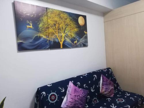 een bank in een kamer met een schilderij aan de muur bij Aj booking in Manilla