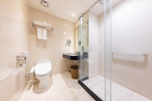 a bathroom with a toilet and a glass shower at Taoyuan Yuehua Hotel & Golf Club in Longtan