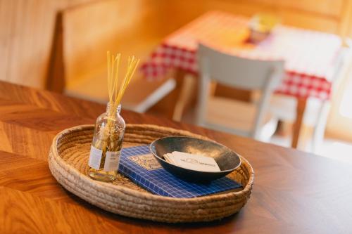 a tray with a bowl and a bottle on a table at The Farmhouse in Sedrun