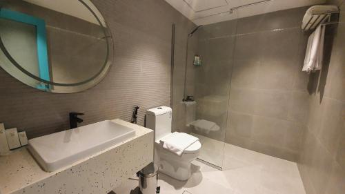 un bagno con lavandino, water e specchio di Al Rayyan Tower a Gedda