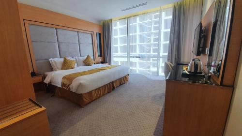 a hotel room with a bed and a large window at Al Rayyan Tower in Jeddah