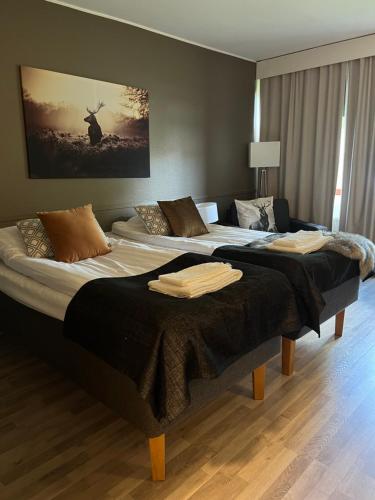Vuode tai vuoteita majoituspaikassa Ellivuori Rooms suurempi hotellihuone 24m2 järvinäköalalla Hyvä varustelu