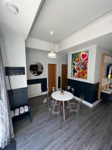 a living room with a table and chairs and a painting at Hot tub, Fire Pit, 4 Acre garden, Luxury 5 Star Woodland Lodge in Skegness