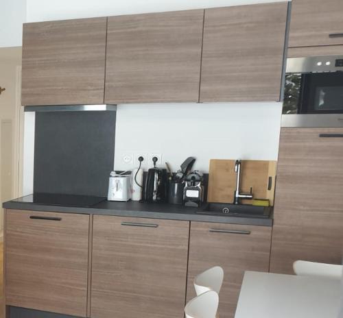 a kitchen with wooden cabinets and a counter top at Résidence-Chalet de Prestige Aspen Park - 106 in Saint-Étienne-de-Tinée