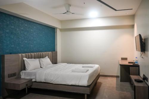 - une chambre avec un lit et un mur bleu dans l'établissement Hotel VR Grand, à Vizianagram City