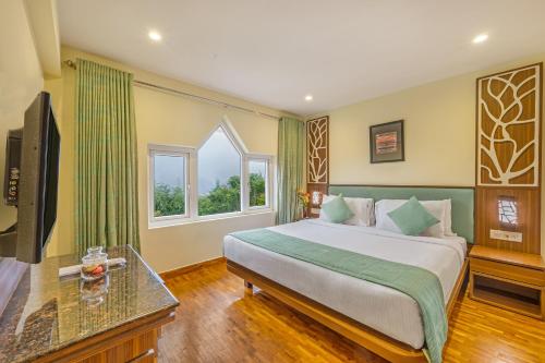 a bedroom with a large bed and a television at Sterling Ooty Elk Hill in Ooty