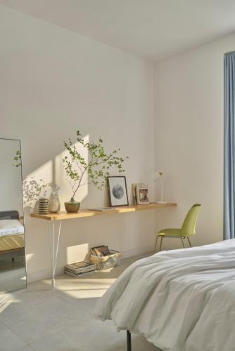 a bedroom with a bed and a table and a chair at M Village Living 47 Thảo Điền in Ho Chi Minh City