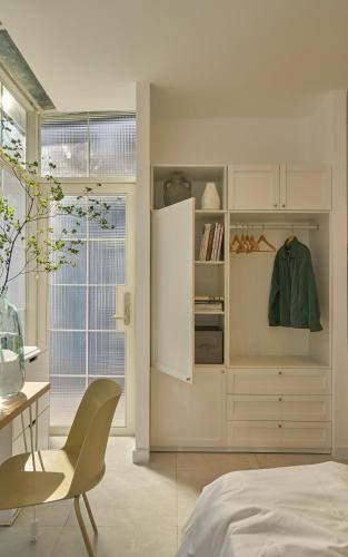 a bedroom with a bed and a desk and a chair at M Village Living 47 Thảo Điền in Ho Chi Minh City