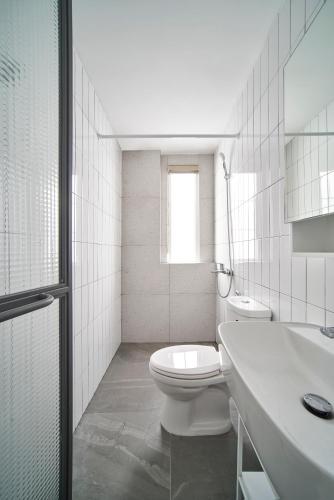 a white bathroom with a toilet and a sink at M Village Living 47 Thảo Điền in Ho Chi Minh City