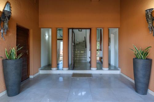 a hallway of a house with two potted plants at San Lameer Villa - 14014 - 5 Bedroom Luxury - 10 pax - San Lameer Rental Agency in Southbroom