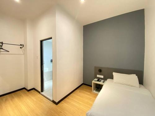 a bedroom with a white bed and a mirror at ARENA Boutique Hotel Kuala Terengganu in Kuala Terengganu
