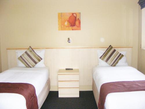 a hotel room with two beds and a picture on the wall at Blenheim Spa Motor Lodge in Blenheim