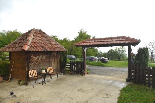 a wooden shelter with two chairs and a table at Njih tri Jelova gora in Užice