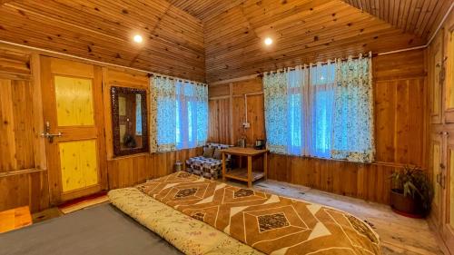 a bedroom with a large bed in a wooden room at The Misty Wilds Home, Jibhi in Jibhi