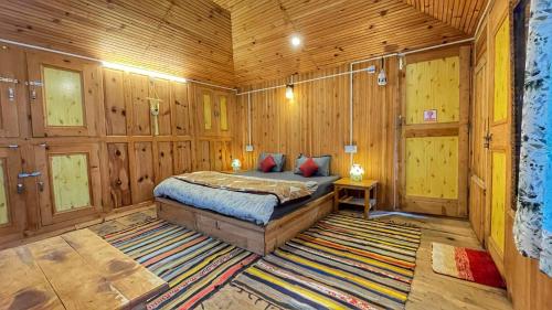 a bedroom with a bed in a wooden room at The Misty Wilds Home, Jibhi in Jibhi