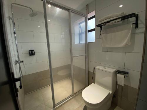a bathroom with a toilet and a glass shower at ARENA Boutique Hotel Kuala Terengganu in Kuala Terengganu
