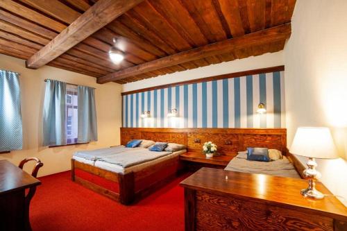 a bedroom with two beds and a desk in a room at Hotel Galerie in Roudnice nad Labem