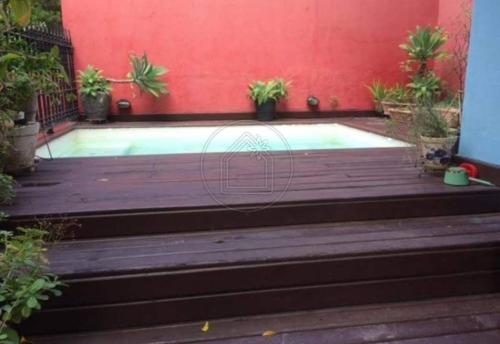 a swimming pool with a red wall and stairs at Santa Teresa Junto à Natureza in Rio de Janeiro