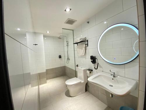 a bathroom with a toilet and a sink and a mirror at ARENA Boutique Hotel Kuala Terengganu in Kuala Terengganu