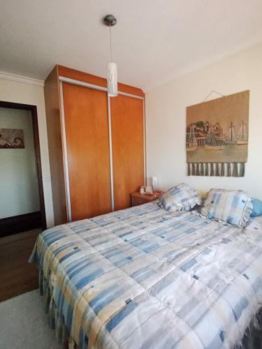 a bedroom with a large bed with a wooden door at Apartamento T3 Furadouro in Ovar