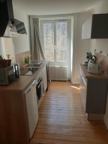 Il comprend une cuisine dotée de parquet et d'une fenêtre. dans l'établissement Appartement cosy face à la Mayenne, à Laval