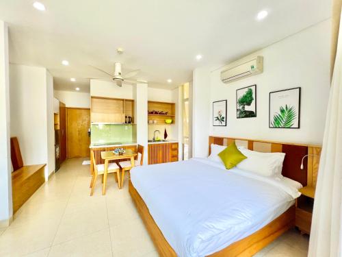 a bedroom with a bed and a desk in a room at Babylon Garden Da Nang in Da Nang