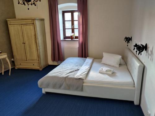 a bedroom with a white bed and a window at Kaštieľ Ottlýk in Bánovce nad Bebravou