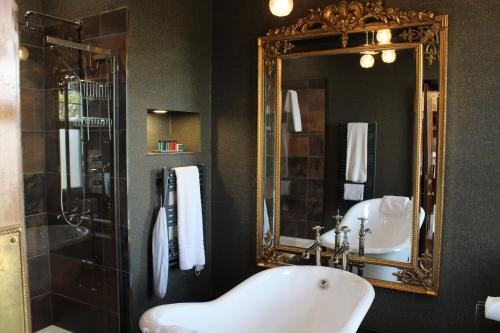 a bathroom with a white sink and a mirror at Falls of Lora Hotel in Oban