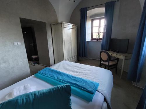 a bedroom with a bed and a desk and a window at Kaštieľ Ottlýk in Bánovce nad Bebravou