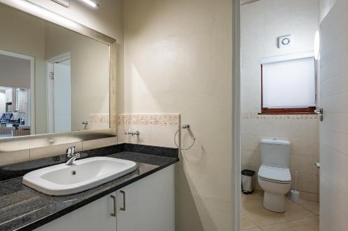 een badkamer met een wastafel, een toilet en een spiegel bij San Lameer Villa 2851 - 2 Bedroom Classic - 4 pax - San Lameer Rental Agency in Southbroom