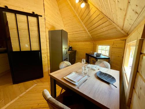 Cette chambre en bois comprend une table dans une cabine. dans l'établissement Alsace kota évasion & Spa la canopée, à Mollkirch