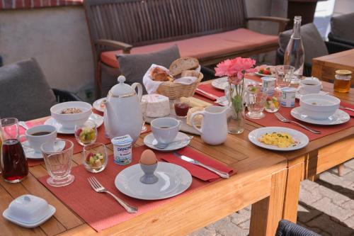 una mesa de madera con comida y platos. en Le Clos Corbier - Champagne Collard-Milesi, en Mareuil-sur-Ay