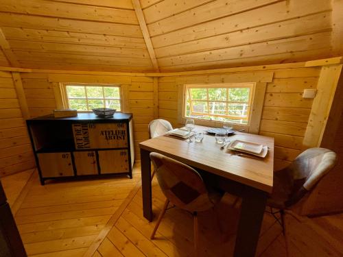 a wooden room with a table and chairs in a cabin at Alsace kota évasion & Spa la canopée in Mollkirch
