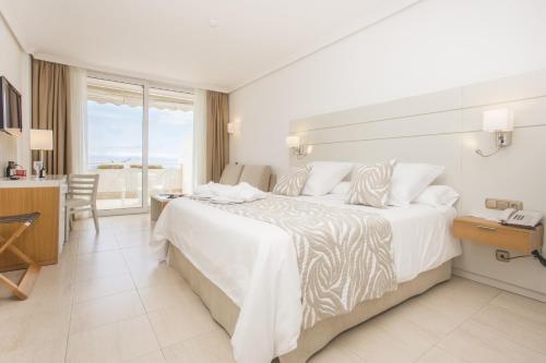 a hotel room with a bed and a desk at Landmar Playa La Arena in Puerto de Santiago