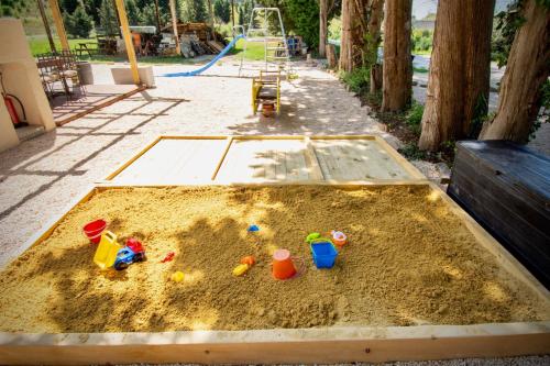 a sandbox with toys in the sand in a park at Gîte de Fanny du Moulin de Tartay en Avignon in Avignon